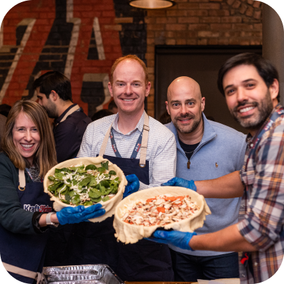 A group of people in Kraft Heinz clothing, holding up food to show to the camera.