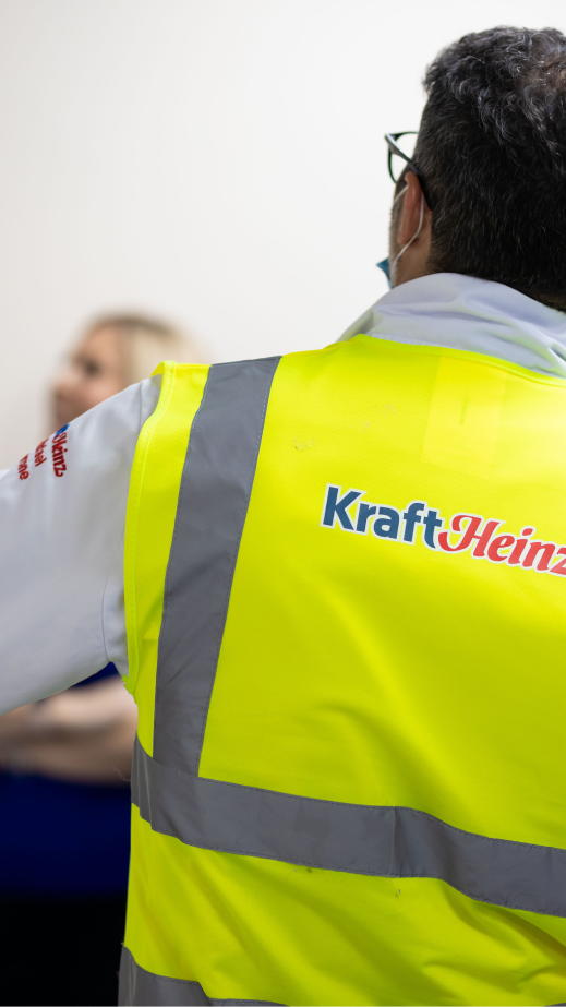 A man in a high visibility vest with his back to the camera