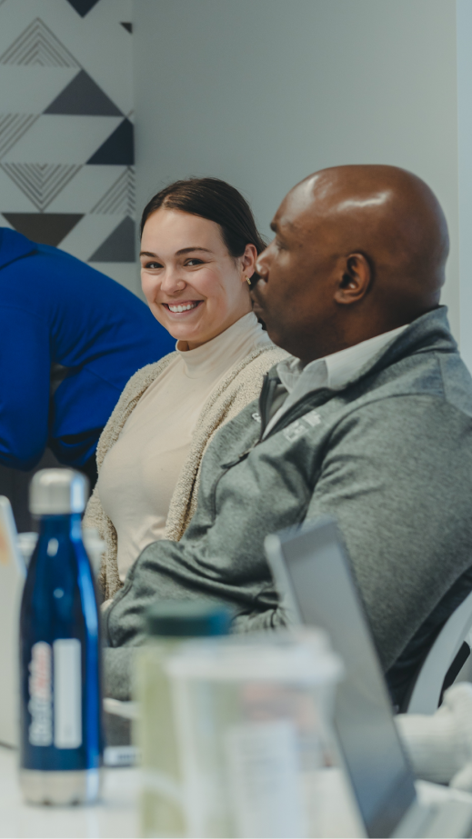 a man and a woman who is smiling, seated at a table