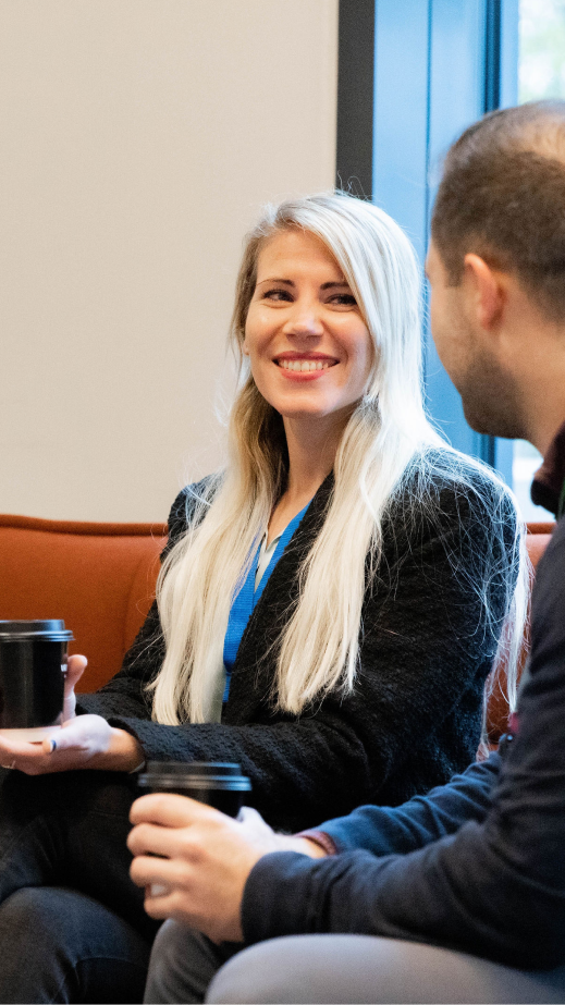 A woman smiling while in conversation with a man