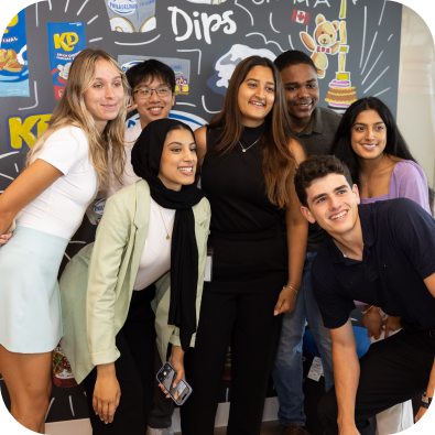 A group of people posing in front of a chalkboard wall.
