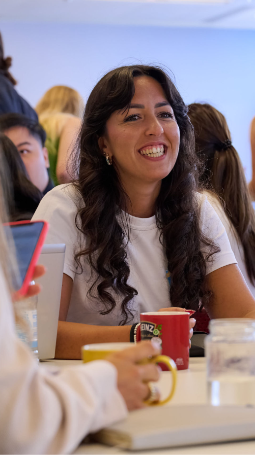 a woman sitting a table smiling