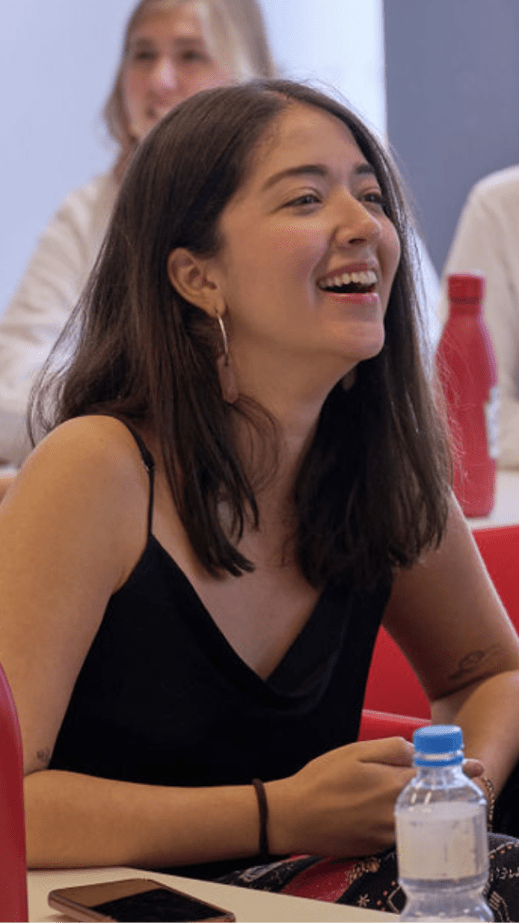 A woman in a black top smiling, looking to the right.